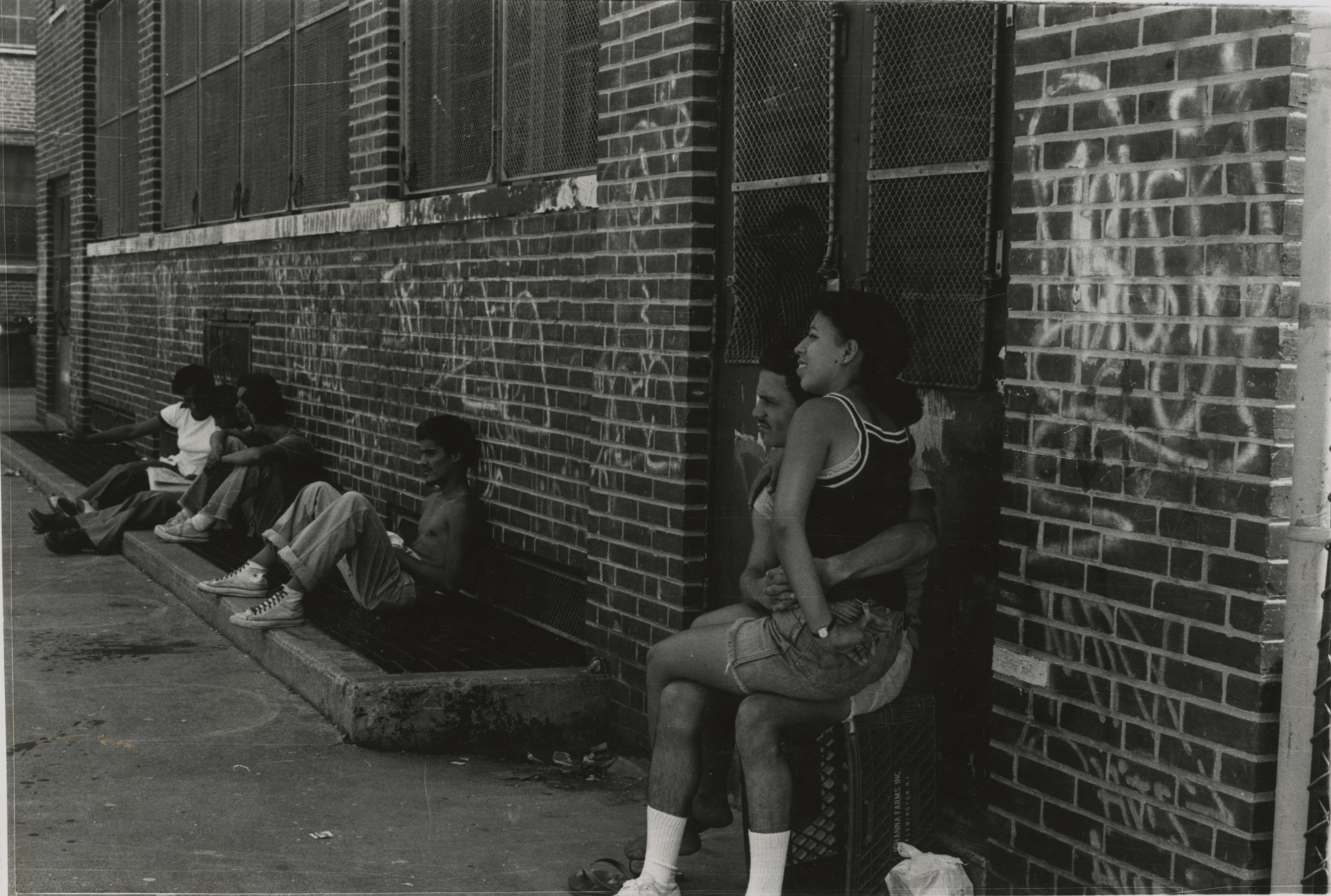 Puerto Rican youth socialize in graffitied side-street