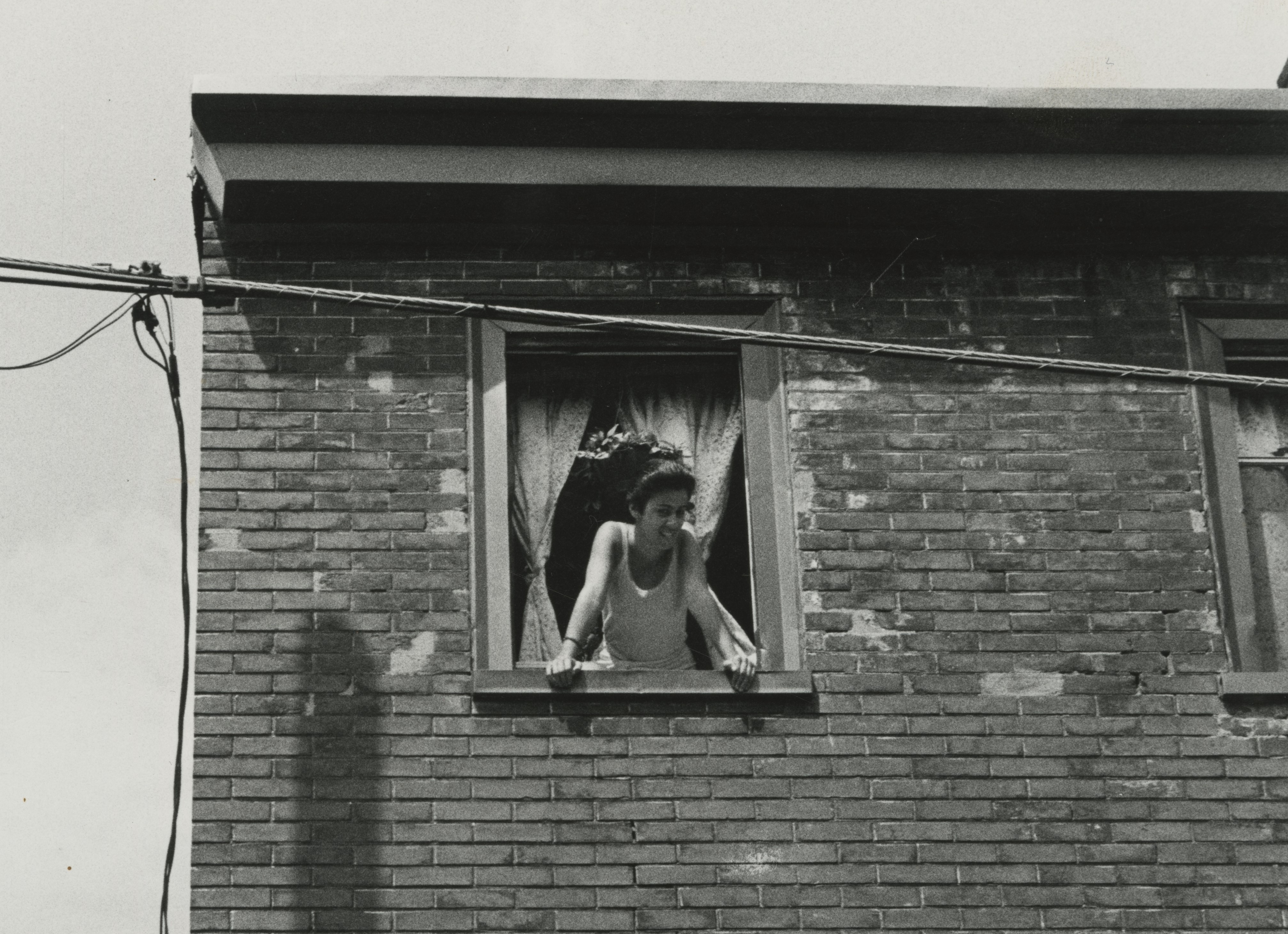 Woman leans out apartment window